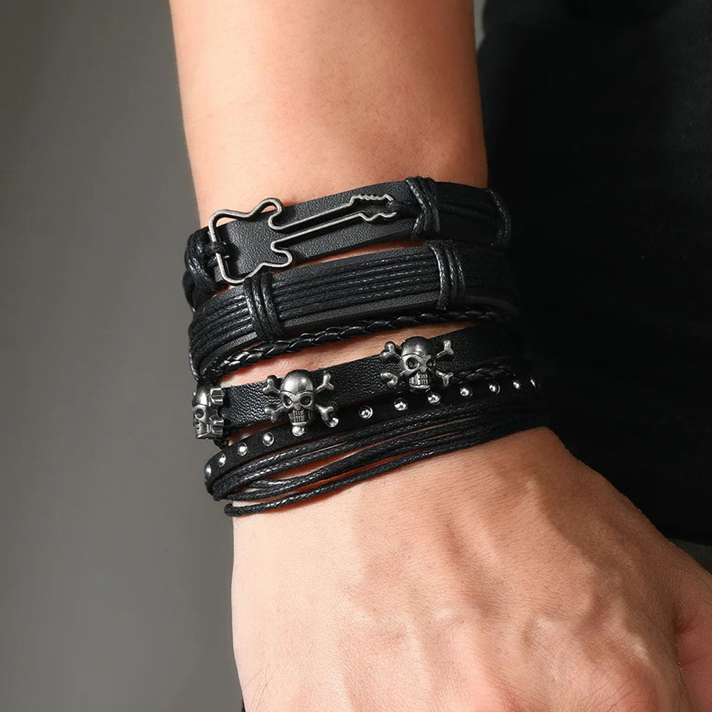 Svartfärgade läderarmband med nitar föreställande kranium och en elgitarr