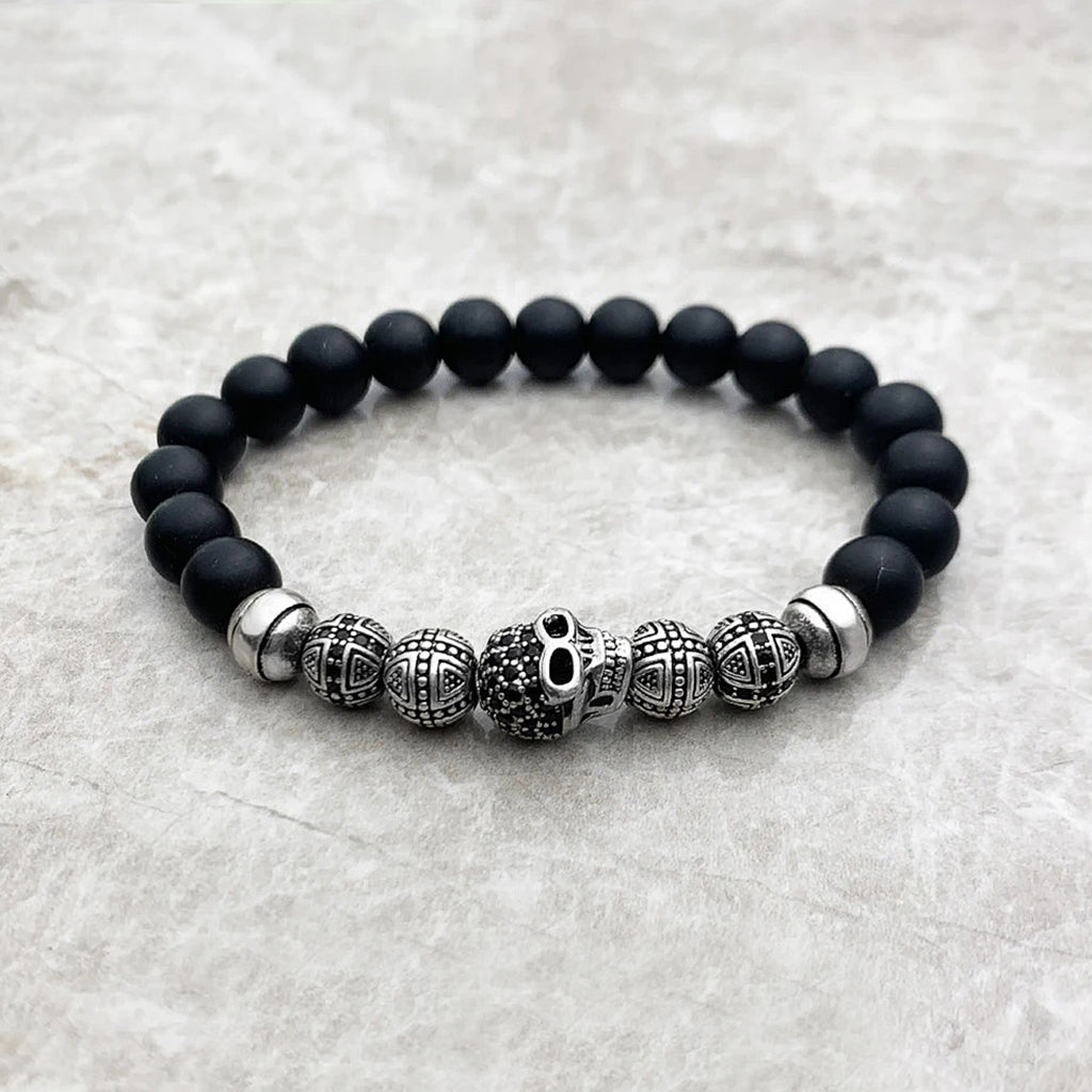 Pärlarmband med svarta pärlor och silverkulor, varav en är en zirkonprydd dödskalle
