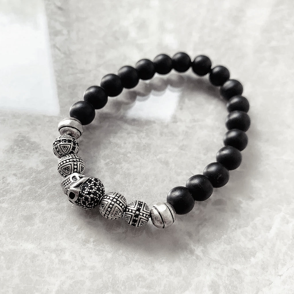 Pärlarmband med svarta pärlor och silverkulor, varav en är en zirkonprydd dödskalle
