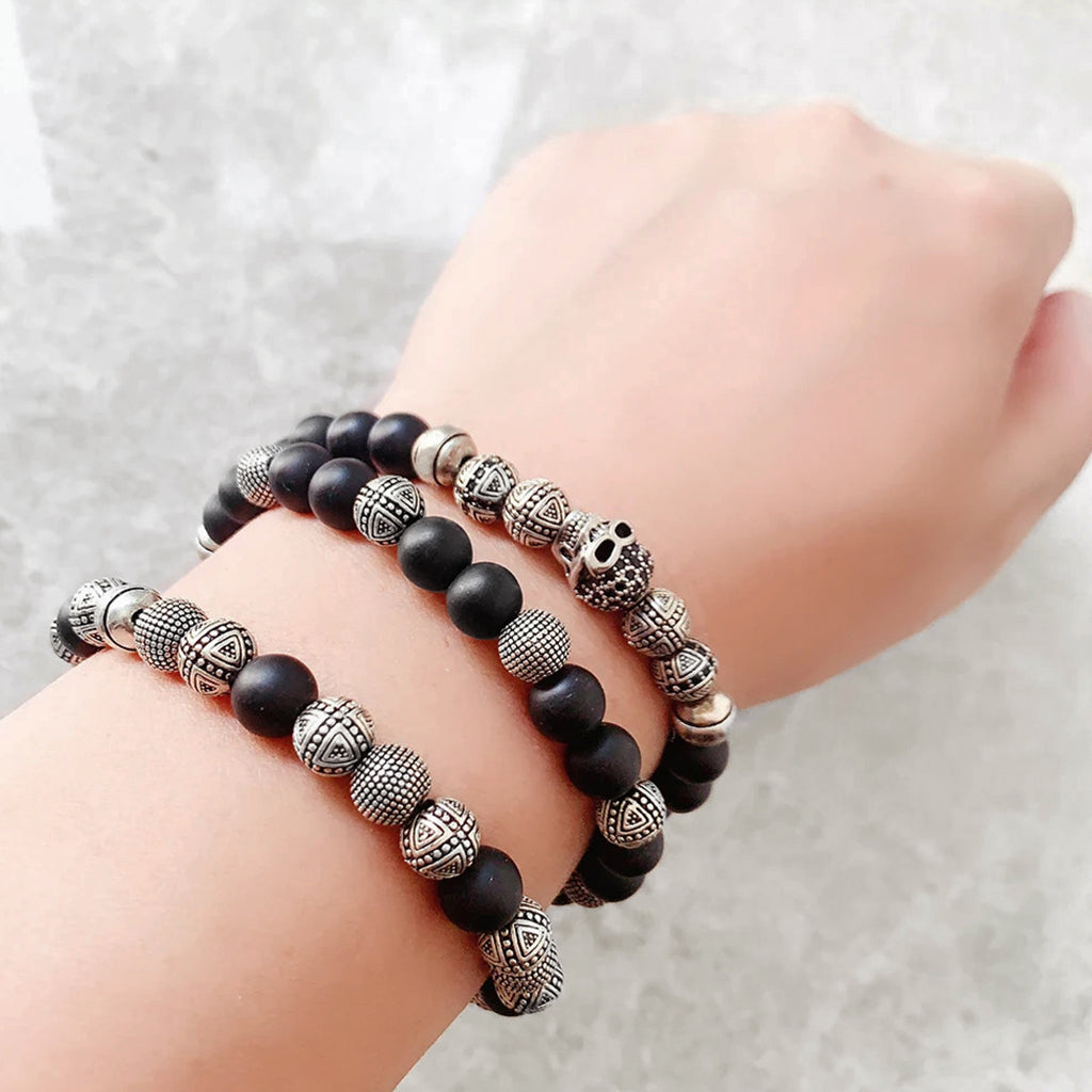 Pärlarmband med svarta pärlor och silverkulor, varav en är en zirkonprydd dödskalle