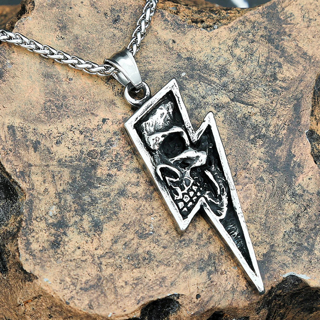 Silverfärgat halsband föreställande en blixt med en dödskalle invändigt