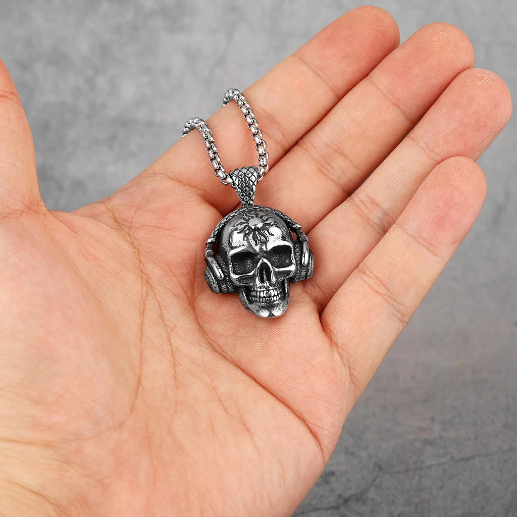 Silverfärgat smycke föreställande en dödskalle med hörlurar