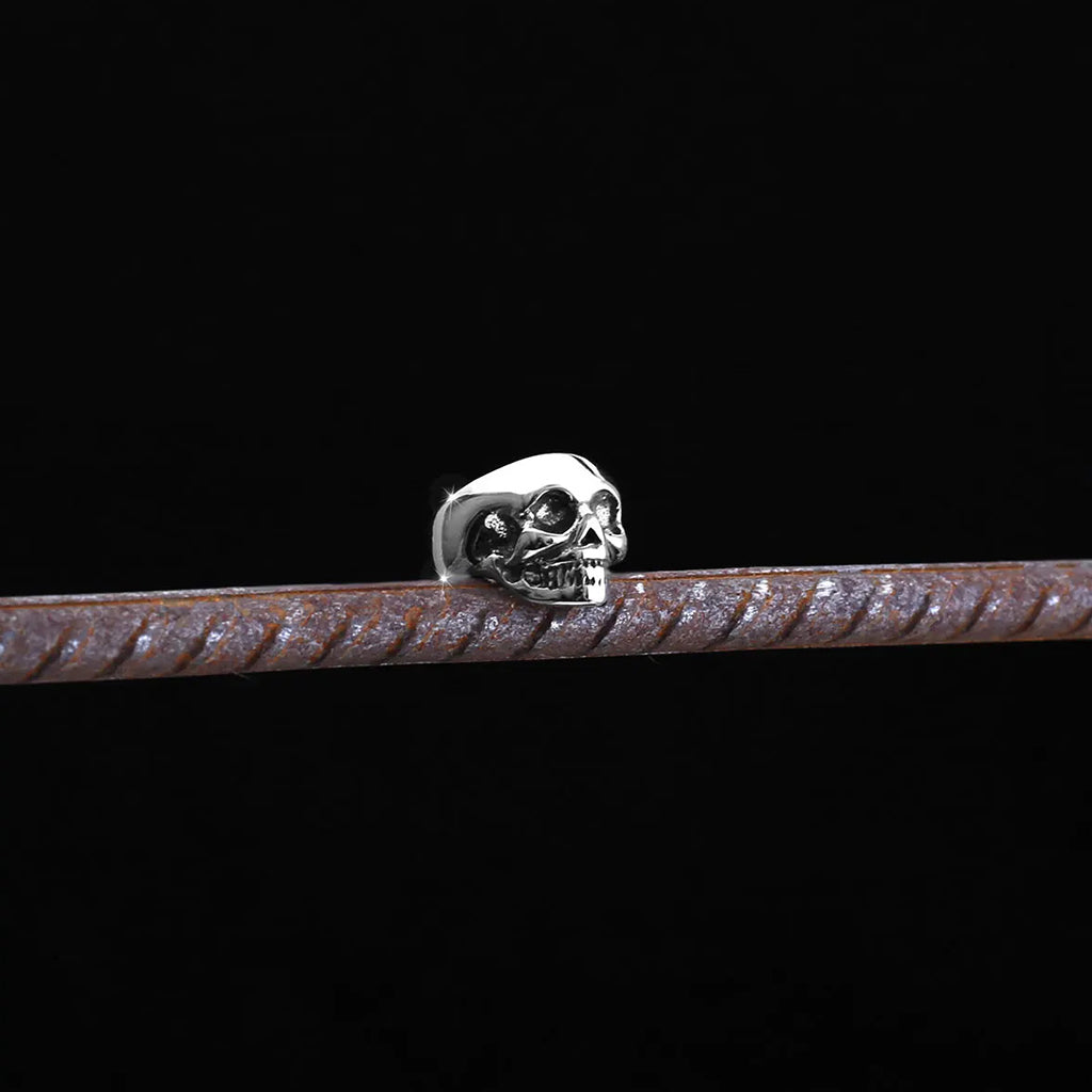 Silverfärgade öronsmycken som är formade som dödskallar