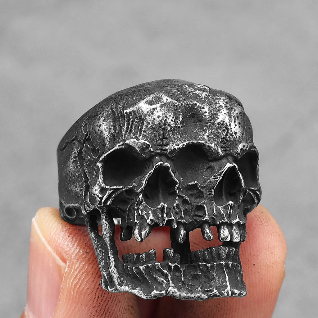 Ring i svärtat stål som visar två dödskallar som sitter ihop