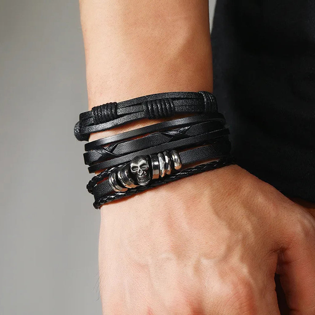 Mörka flätade armband med nitar föreställande en dödskalle och ringar