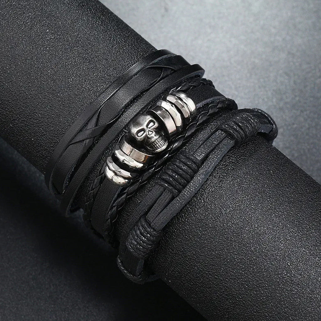 Svarta flätade armband med nitar föreställande ett kranium och ringar