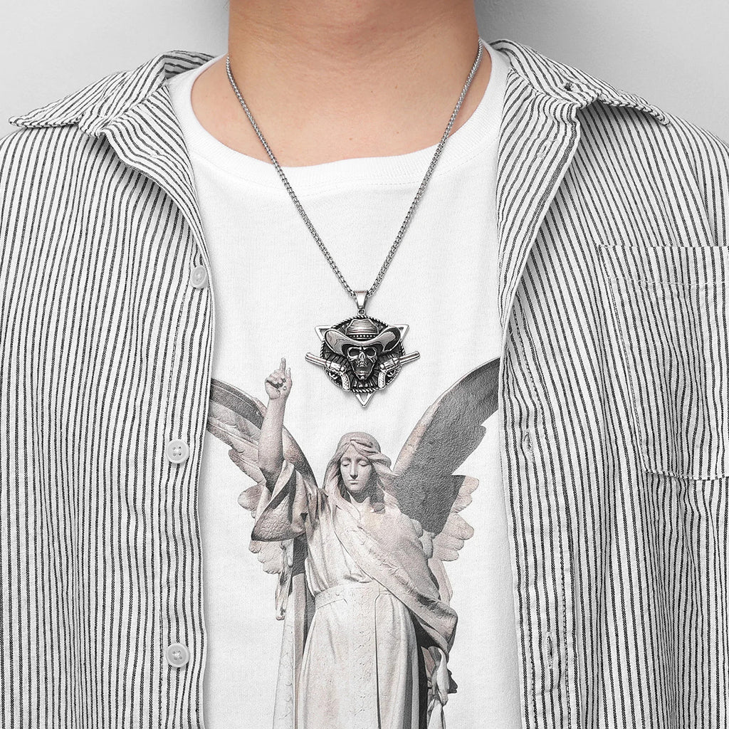 Silverfärgat hängsmycke föreställande en cowboy dödskalle med två vapen