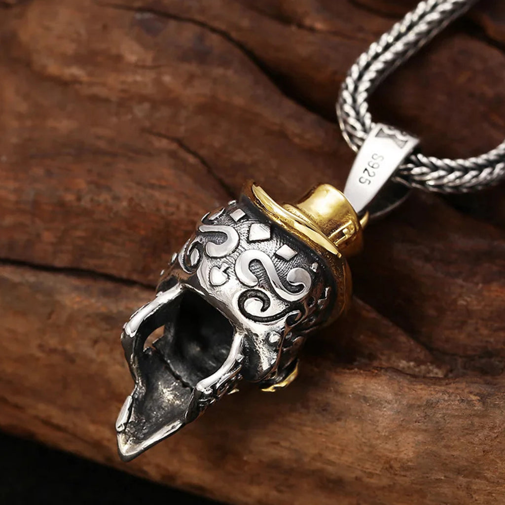 Silverfärgat sterling silver halsband föreställande en dödskalle med guldfärgad hatt, mustasch och monokel