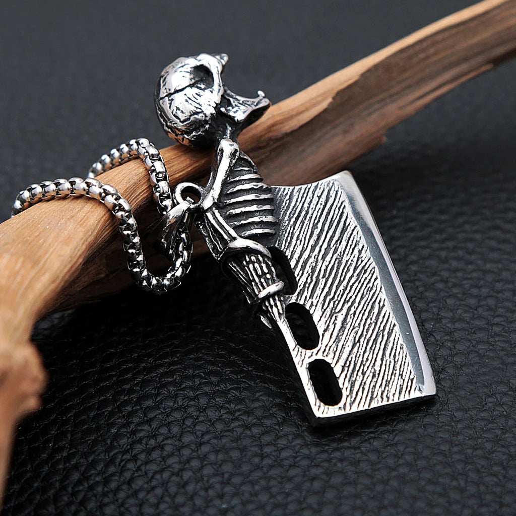Silverfärgat hängsmycke föreställande en liten slaktkniv med en gapande dödskalle, som fungerar som kapsylöppnare