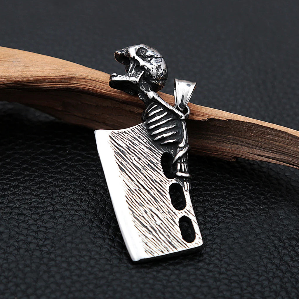 Silverfärgat hängsmycke föreställande en liten slaktkniv med en gapande dödskalle, som fungerar som flasköppnare