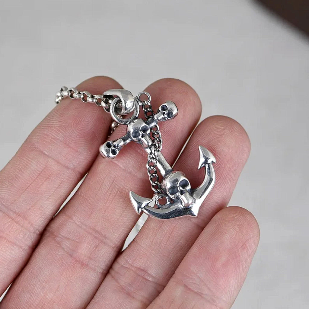 Silverfärgat halsband föreställande ett fartygsankare med en dödskalle på