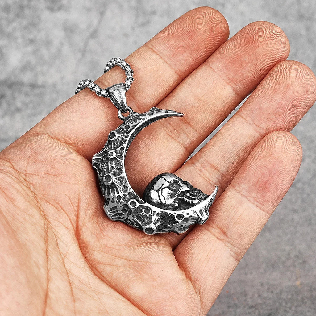 Silverfärgat hängsmycke föreställande en halvmåne med en dödskalle