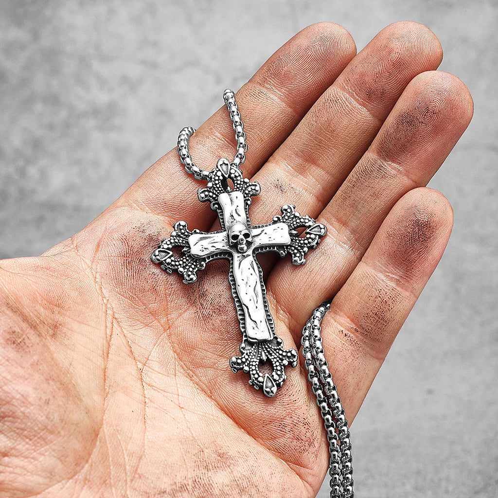 Hängsmycke föreställande ett latinskt kors med vackra ornament och en dödskalle i centrum