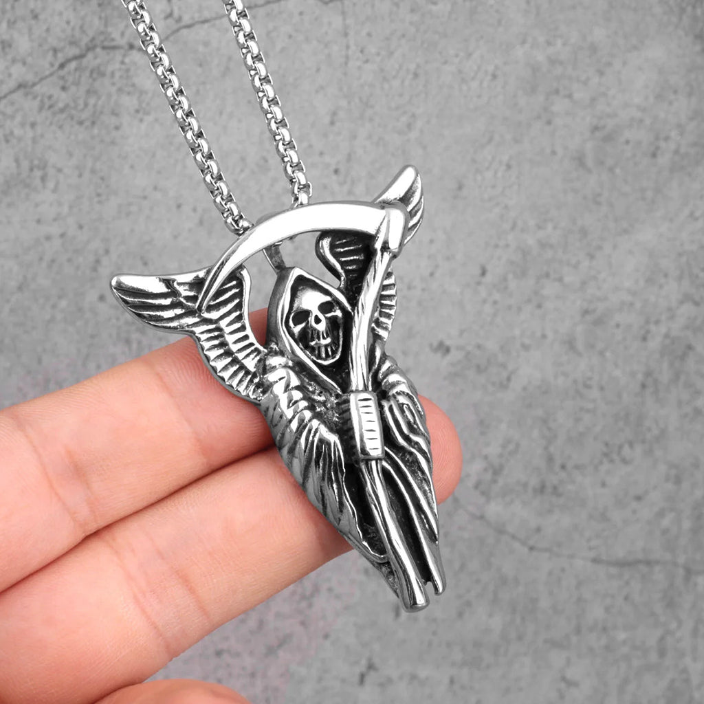 Silverfärgat halsband föreställande Liemannen med änglavingar, hållande i sin lie