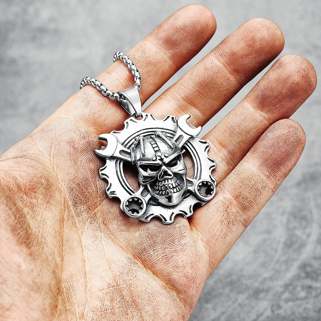 Silverfärgat hängsmycke föreställande ett kugghjul med en dödskalle med korslagda skiftnycklar