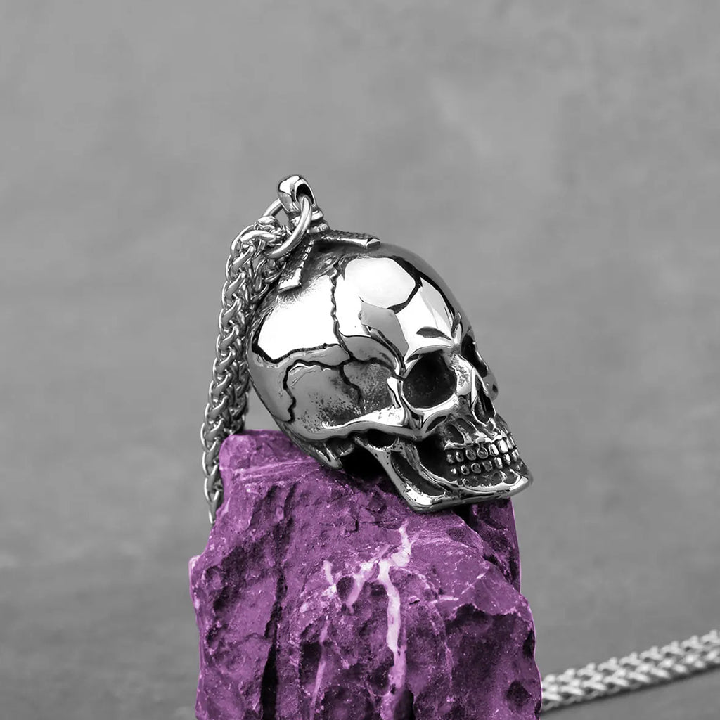 Hängsmycke föreställande silverfärgad dödskalle med sprickor