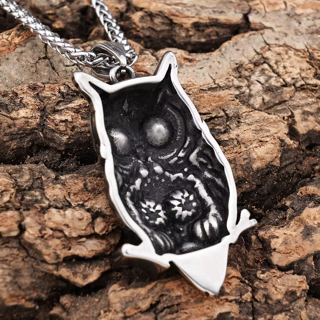 Silverfärgat halsband föreställande en uv och en dödskalle