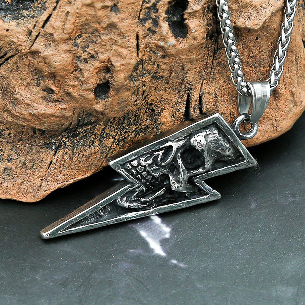 Silverfärgat halsbandshänge föreställande en blixt med en dödskalle invändigt