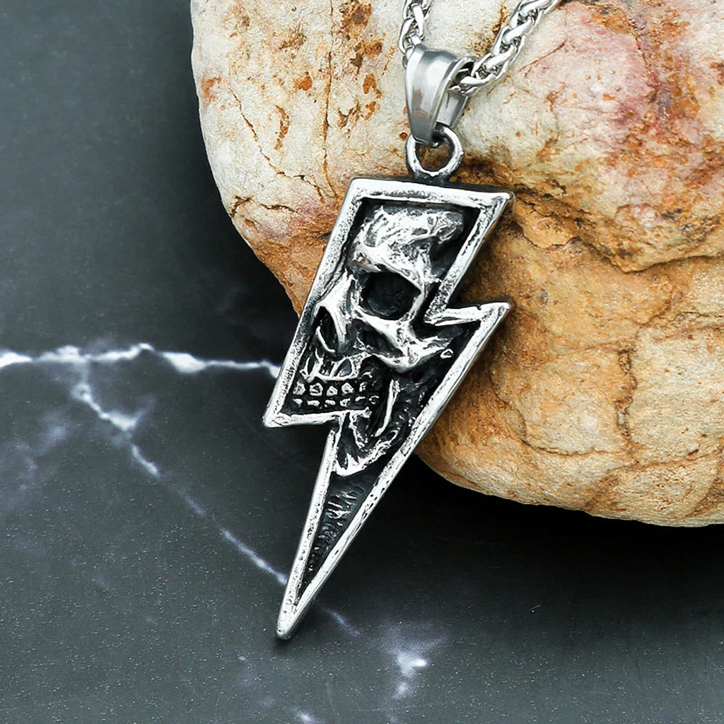 Silverfärgat hänge föreställande en blixt med en dödskalle invändigt