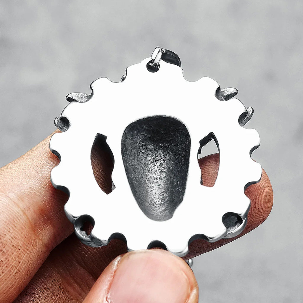 Silverfärgat hängsmycke föreställande ett kugghjul med en dödskalle med korslagda skiftnycklar