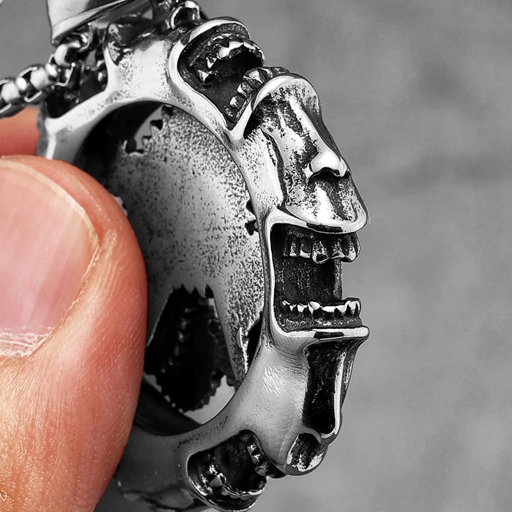 Runt hänge i stål med kugghjul och skrikande ansikten runtom