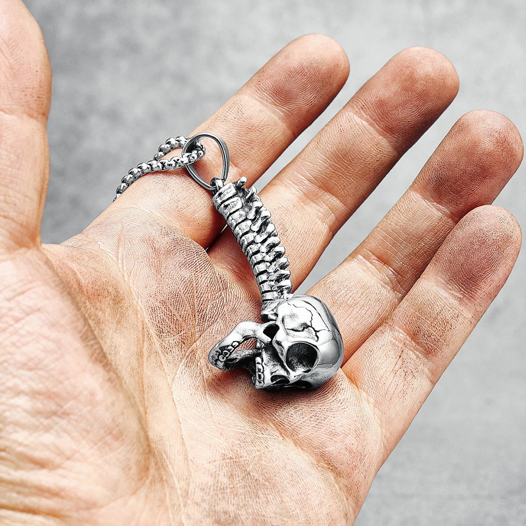 silverfärgade hängsmycke föreställande en ryggrad med en dödskalle längst ut