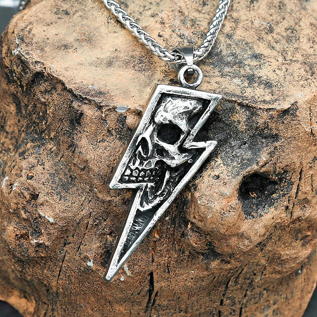 Silverfärgat hängsmycke föreställande en blixt med en dödskalle invändigt