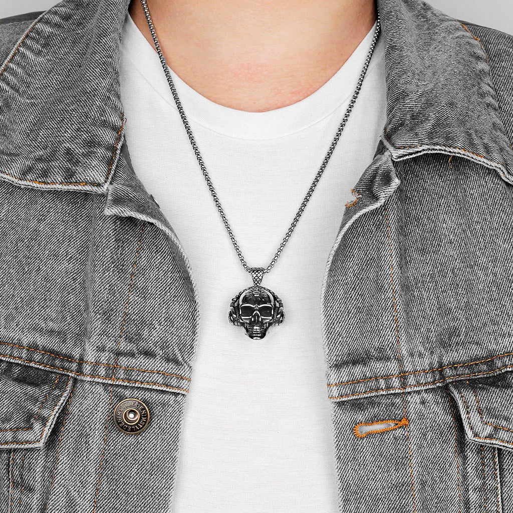 Silverfärgat hängsmycke föreställande en dödskalle med hörlurar