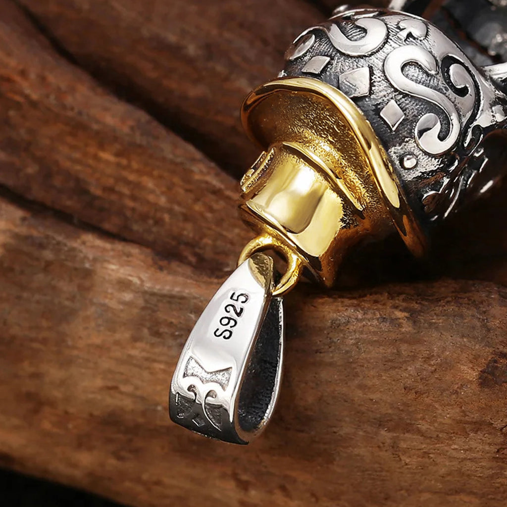 Silverfärgat sterlingsilver hängsmycke föreställande en dödskalle med guldfärgad hatt, mustasch och monokel