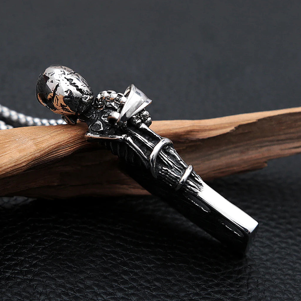 Silverfärgat hängsmycke föreställande en liten slaktkniv med ett gapande kranium, som fungerar som kapsylöppnare