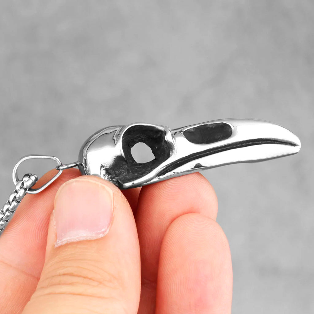 Silverfärgat hängsmycke föreställande kraniet från en korpfågel