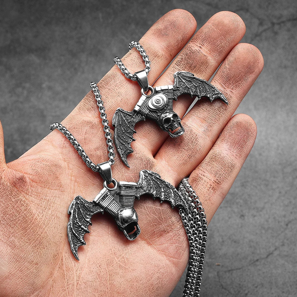 Silverfärgat hängsmycke föreställande en motorcykelmotor med en dödskalle och fladdermusvingar