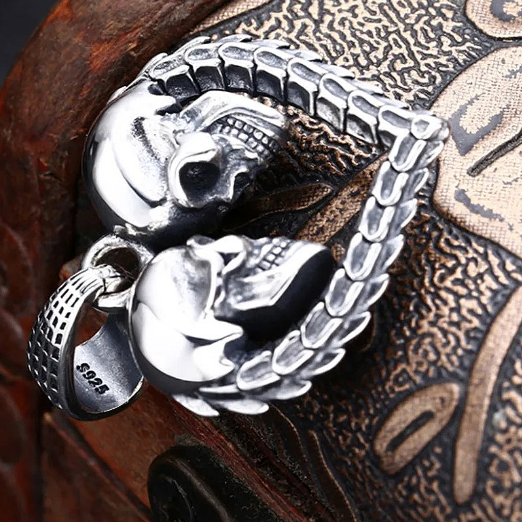 Silver smycke föreställande ett hjärta med två dödskallar