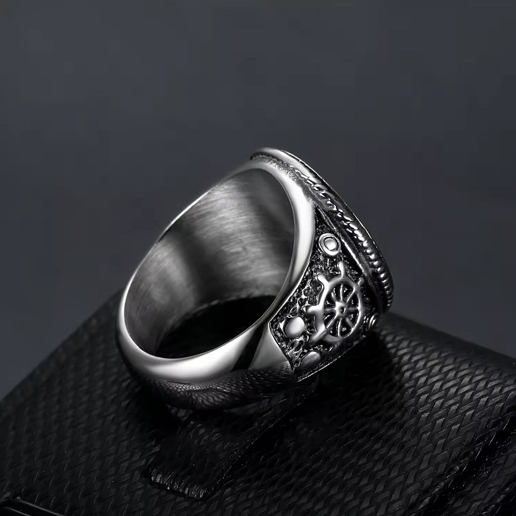 Silverfärgad dödskallering i rostfritt stål med två korsade svärd på klacken