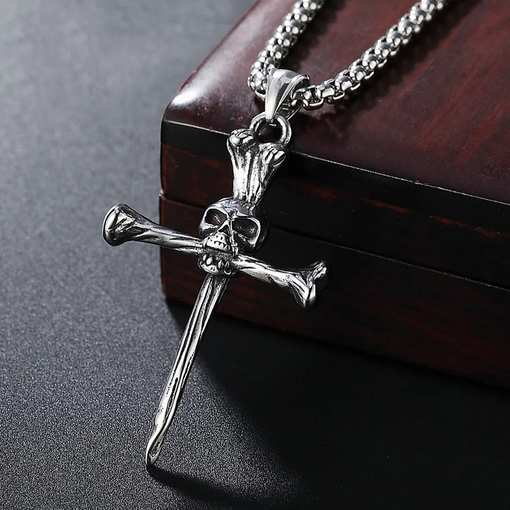 Silverfärgat smycke föreställande ett benknotor-kors med en dödskalle i centrum