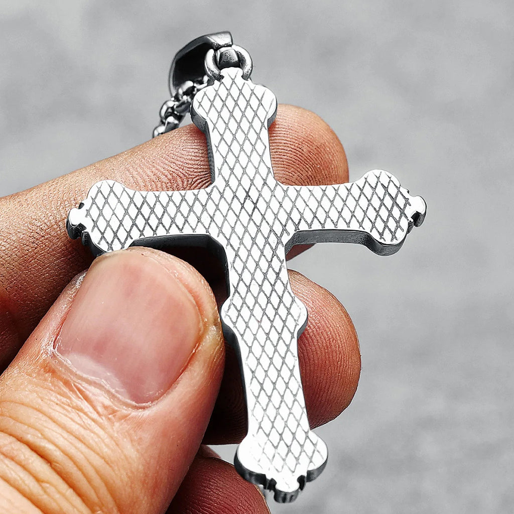 Silverfärgat hängsmycke föreställande ett latinskt kors med ett kranium i mitten