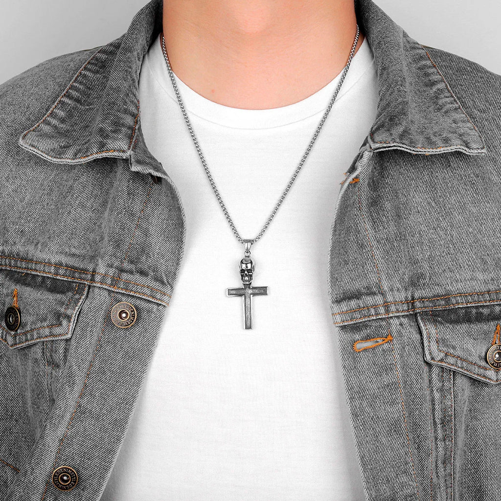 Silverfärgat smycke föreställande ett latinskt kors med ett kranium upptill