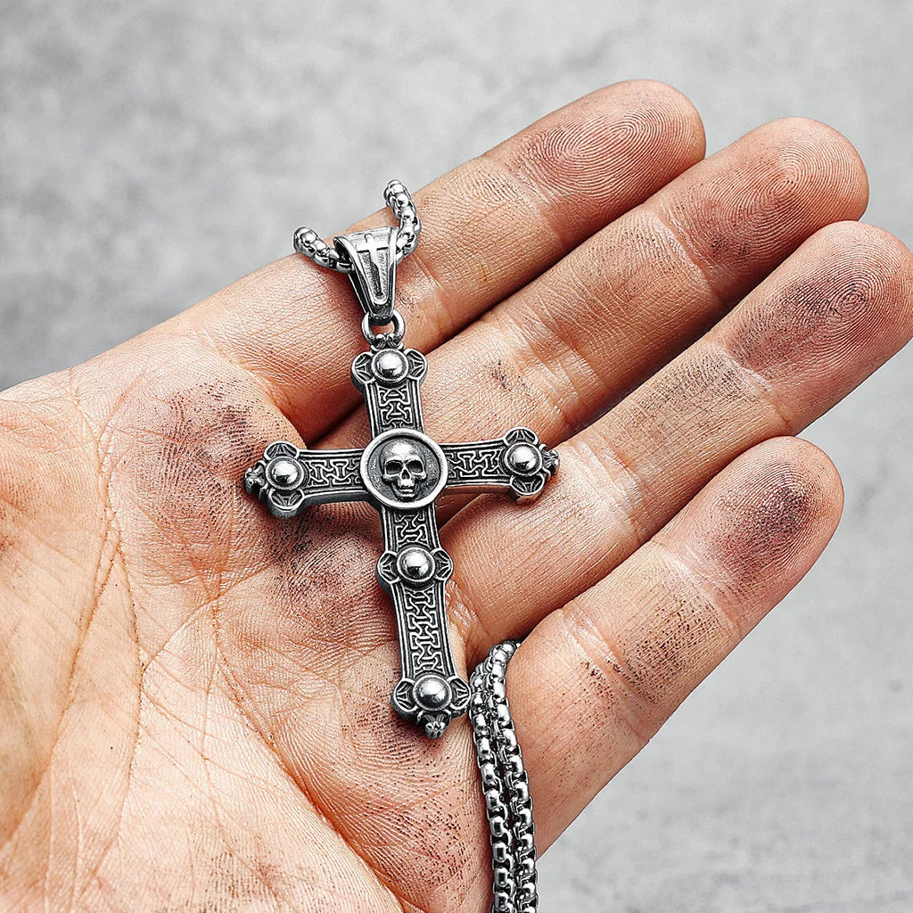 Silverfärgat hängsmycke föreställande ett latinskt kors med en dödskalle i mitten