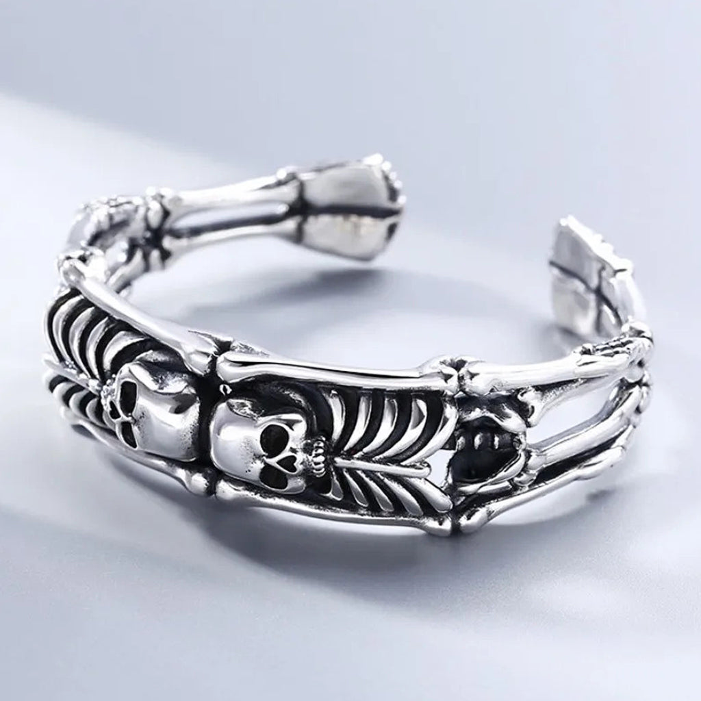 Silverfärgat manschettarmband av sterling silver med två skelett