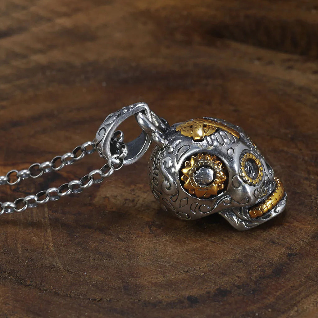 Sterlingsilver smycke föreställande en mexikansk dödskalle med guldfärgade utsmyckningar
