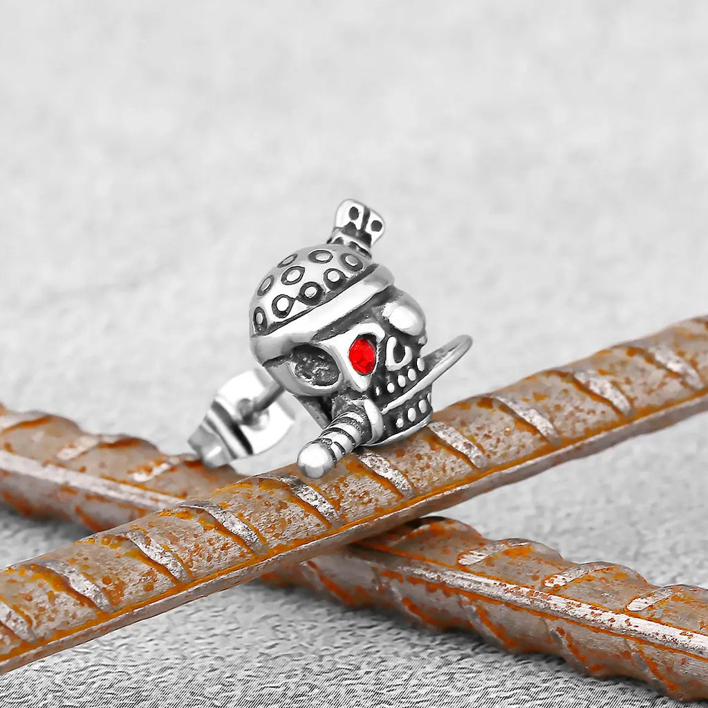 Silverfärgat örhänge föreställande en pirat-dödskalle med bandana, ögonbindel och en kniv i munnen