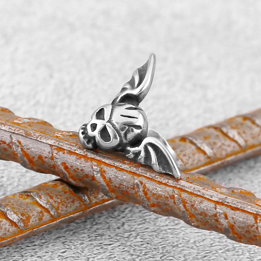 Silverfärgade örhängen föreställande en dödskalle med vingar