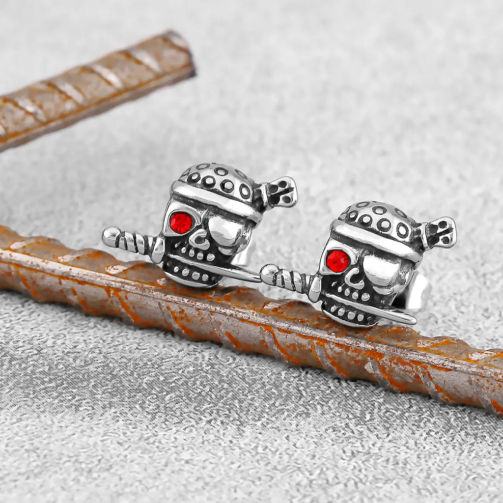 Silverfärgat örhänge föreställande en pirat-dödskalle med bandana, ögonbindel och en kniv i munnen