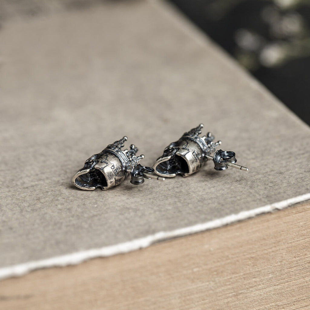 Silverfärgade örhängen i äkta silver föreställande en dödskalle med en krona på skallen