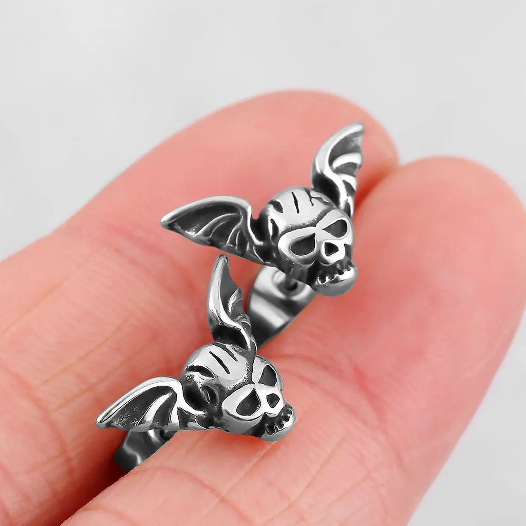 Silverfärgade öronstift föreställande en dödskalle med vingar