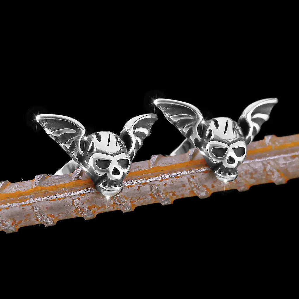 Silverfärgade öronstift föreställande en dödskalle och en fladdermus