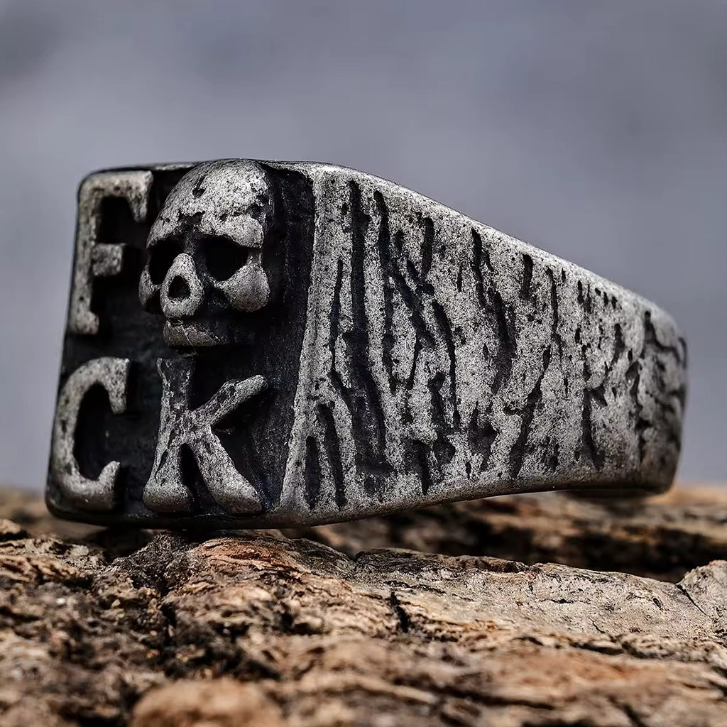 Ring med dödskalle och texten fuck på klacken