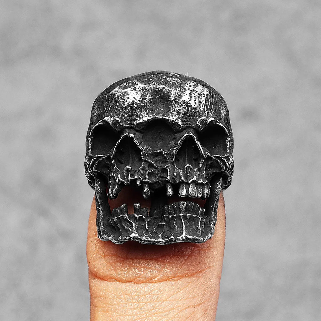 Ring i svärtat stål som visar två dödskallar som sitter ihop