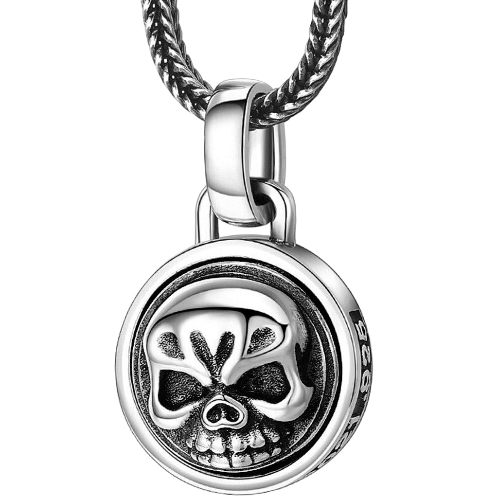 Dubbelsidigt hänge av sterlingsilver, formgivet som ett runt smycke med en roterbar dödskalle