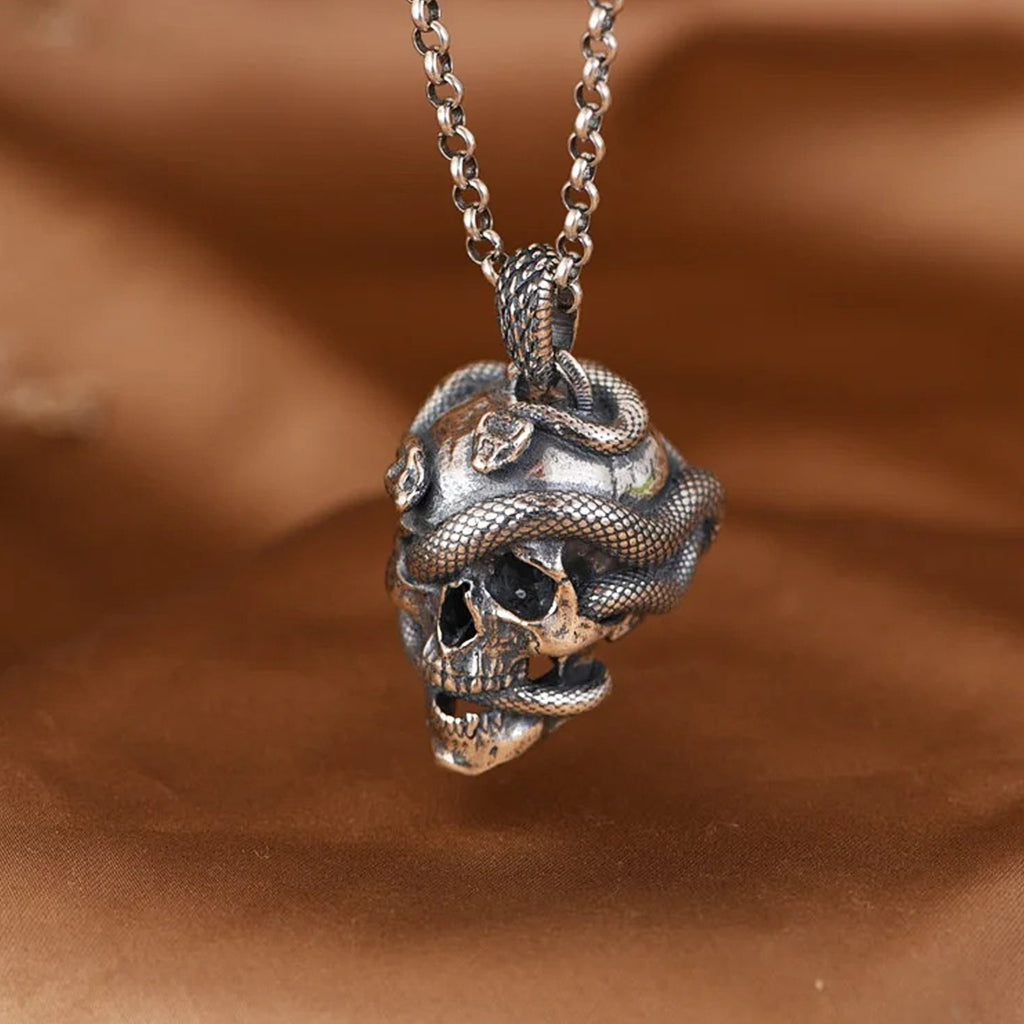 Silver halsband med hänge föreställande en dödskalle med reptiler